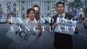 Latino man and woman holding "Abolish ICE" posters with the words "Expanding Sanctuary" overlaid.